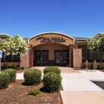 Exterior of dental office building with brick facade, trees, and entrance