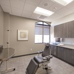 Dental examination room with chair, window, cabinets, and equipment
